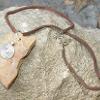 Store bought metal bead, found stone, rawhide